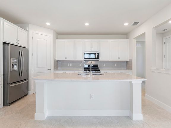 Enjoy making your favorite meals in this kitchen with stainless gas appliances and large quartz cent