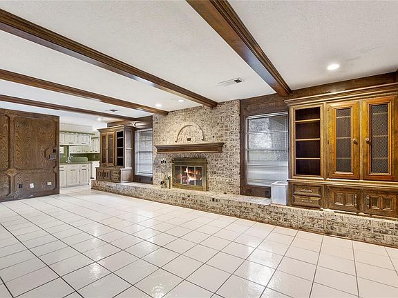 Massive family room with Beams, wood burning fireplace, built-ins, beautifully grafted wood walls. Open to kitchen.