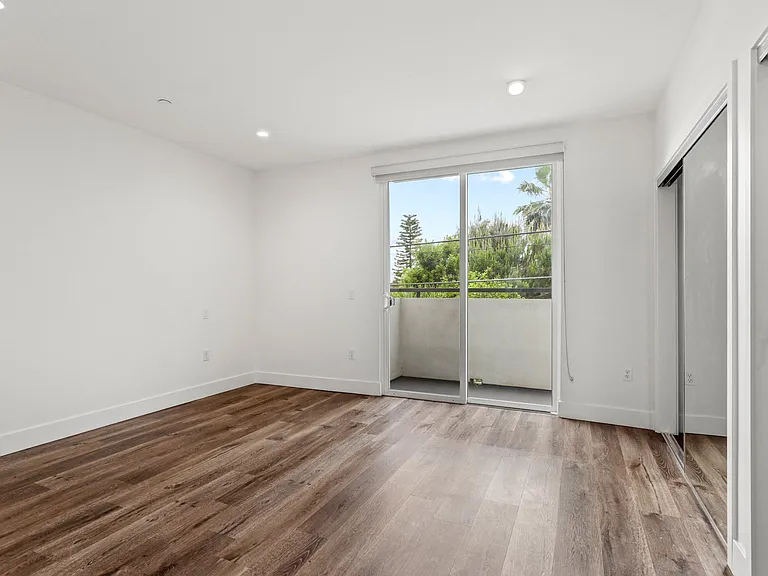 Bedroom with Recessed Lighting, Vinyl Flooring, and Two Mirrored Closets