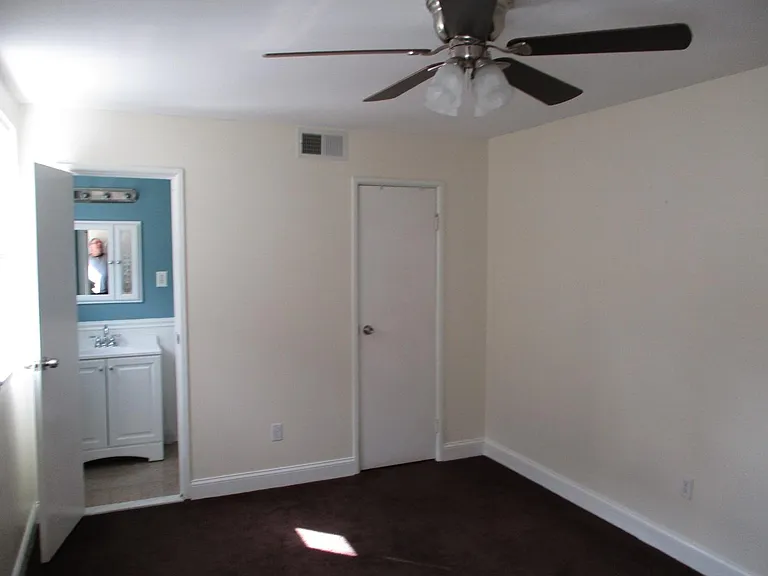 Master Bedroom with lighted ceiling fan. Small Bathoom to the left & Walk in Closet to the right.