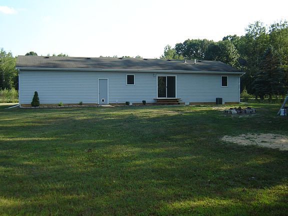 This view shows the back of the  house and a portion of the back yard.   There is plenty of room for fun and games and great place for an evening bon fire.