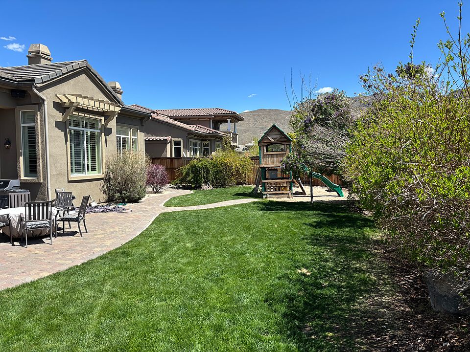 Big back yard with playhouse and fire pit.