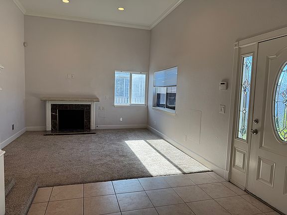 Living room with high ceilings and recessed lighting. Fireplace rendered inoperative.