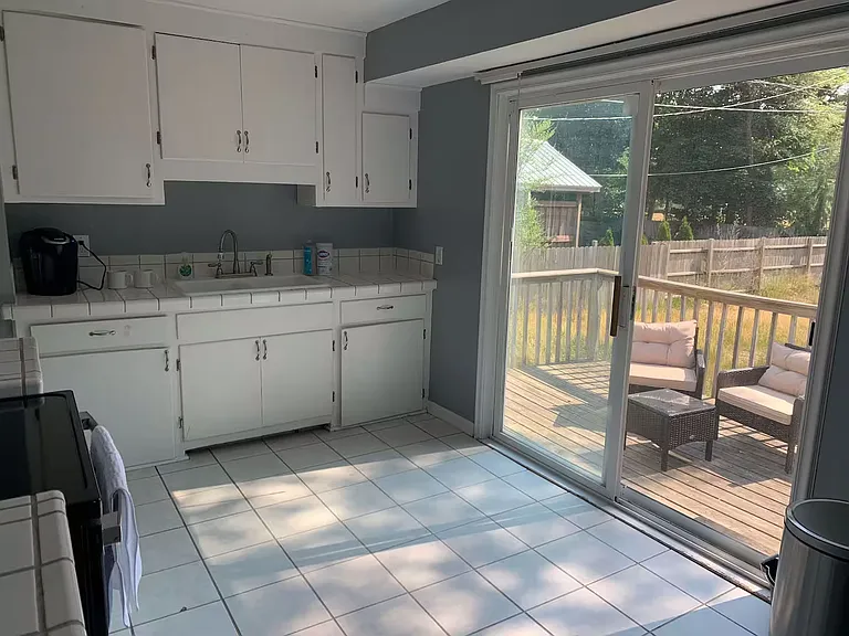 Large sunny kitchen with ceramic tile overlooking private back deck.