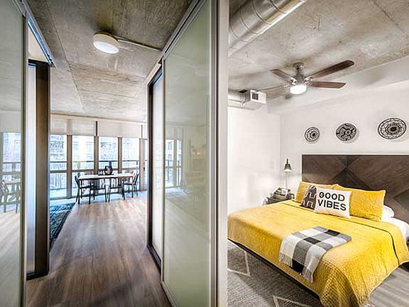 Bedroom with sliding barn door and hard surface flooring