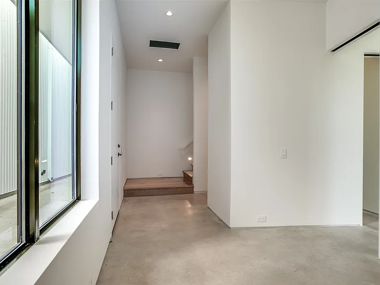 Modern interior hallway with polished concrete flooring and white walls
