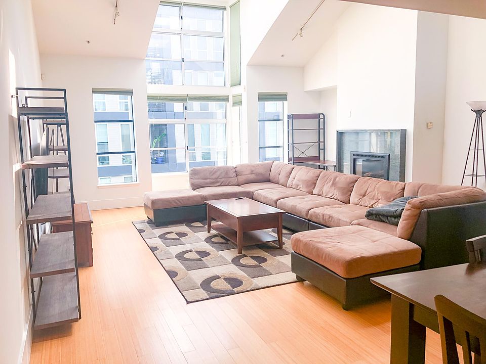 2nd Floor: Sun flooded main Living Area with Fireplace, TV, Couch, Coffee Table etc.