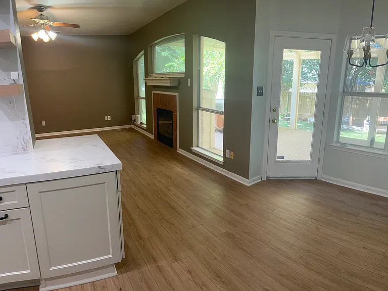 View of Living Room and Breakfast Nook from Kitchen. Perfect spot to have coffee or tea and breakfast. Entrance to back patio is shown - could use breakfast nook for a mud room as well.