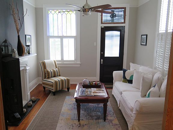 Original stain glass windows, modern ceiling fan with remote and Williams-Sonoma sofa make up the living room.