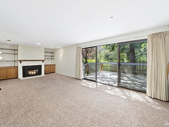 The spacious living area features a cozy gas fireplace flanked by built in cabinets.  The deck has a lovely outlook offering a view of the changing seasons. Enjoy outdoor relaxation and entertaining in this inviting space!