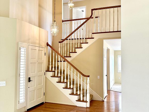 Staircase with chandelier lighting by the front door.