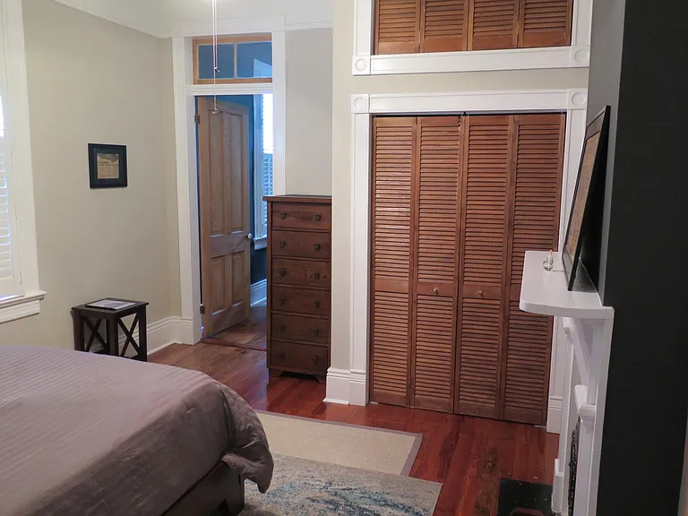 This bedroom closet was custom built during the renovation. it features replica casing and trim found throughout the house. The shutter doors are reflective of the house shutters.