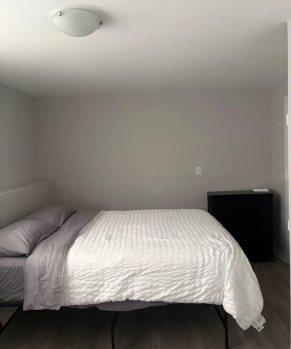 Private bedroom with a full-size bed, neutral walls, and durable flooring, plus space for a dresser or small desk.