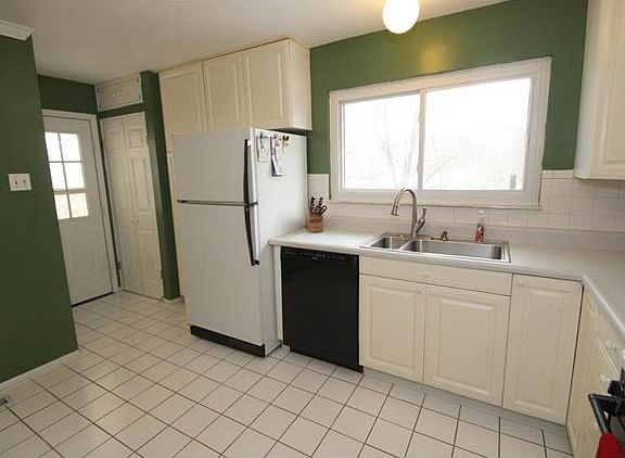 Open and bright Kitchen w/ 42" cabinets, 2 pantries, tile and walk out to covered porch perfect for BBQ!