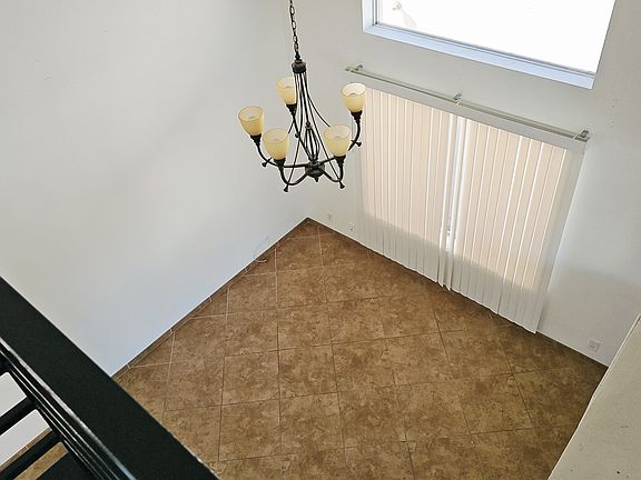 Open loft view overlooking the main living area, showcasing soaring ceilings, natural light, and a spacious open-concept layout.