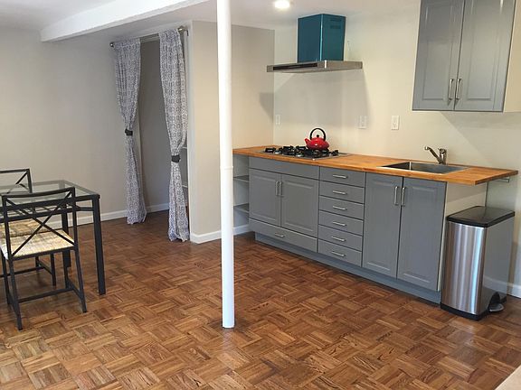 Kitchenette with cooktop, sink and fridge.