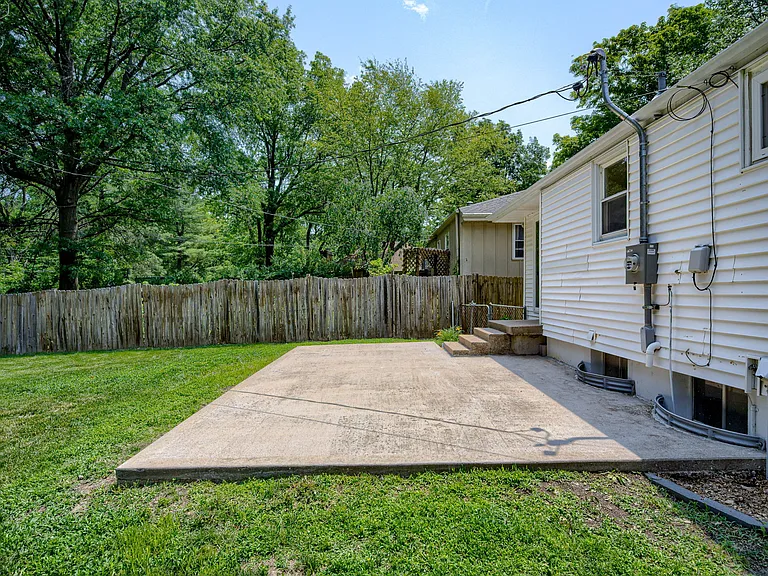 Backyard patio showing the stairs from dining and window wells into basement bathroom + basement laundry room