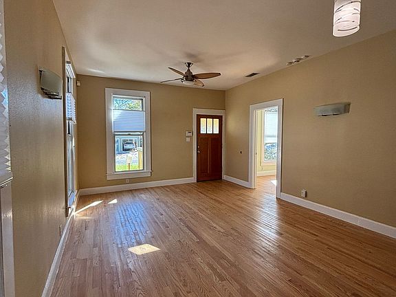 Living / dining room with oak floors. Lots of light from side and front windows.