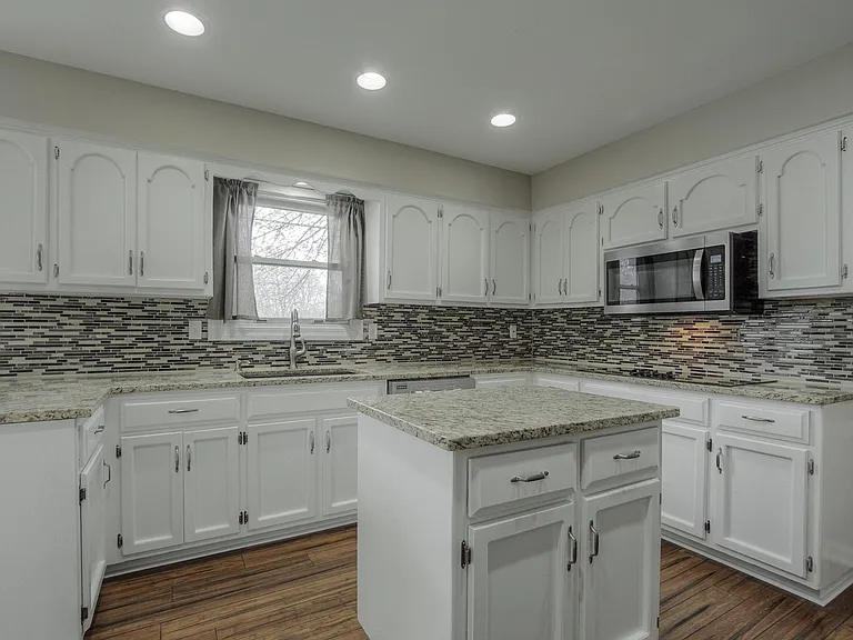 Bright, updated kitchen with stainless steel appliances and ample counterspace. VINY FLOORING BEING REPLACED WITH GRAY TILE.