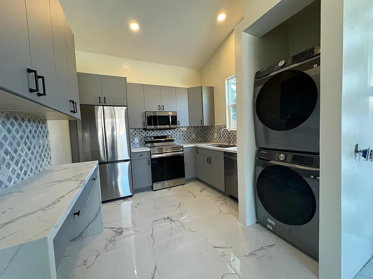 Kitchen with desk area for eating prepping. New stainless steel appliances. Washer/dryer in unit (now deep drawer added under machines that matches the cabinets). Airfryer oven and workstation 36" sink with waterfall wash station and faucet. High ceilings