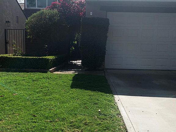 A private pathway covered in Bougainvilla leads to the front, private courtyard of the home