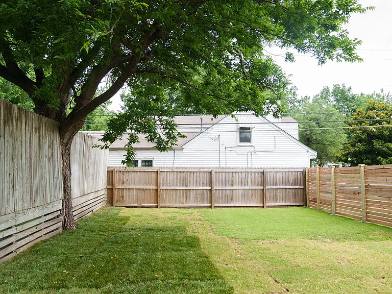 Fenced side yard freshly sodded and new fence on south side