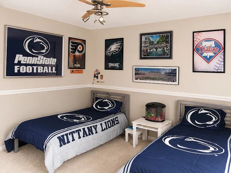 Extra spacious second bedroom with chair rail and ceiling fan