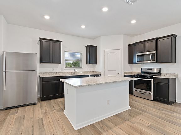 Stunning kitchen with a large island, granite countertops, and a large basin sink.