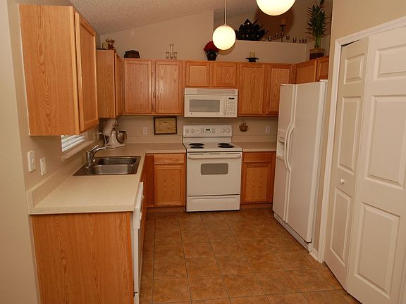 Kitchen features oak cabinets and pantry.