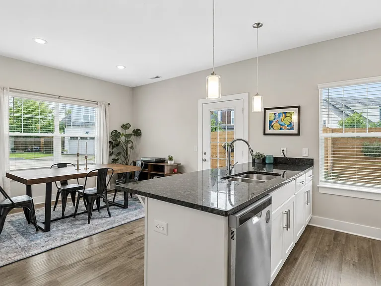 Open dining space adjacent to the kitchen with views of the fenced backyard