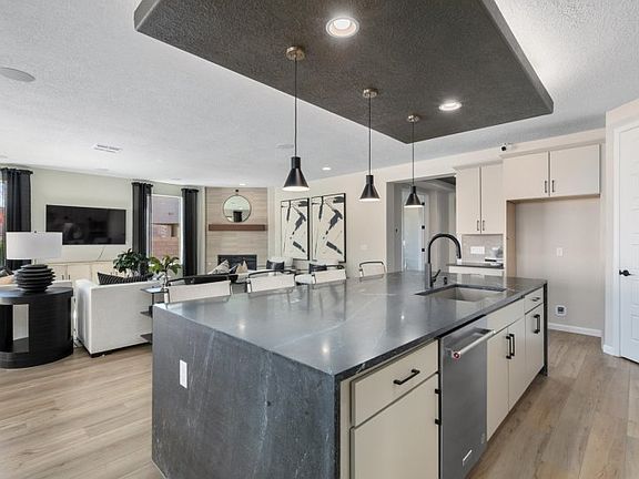 Large kitchen island features a built-in bar overlooking an open floor plan.