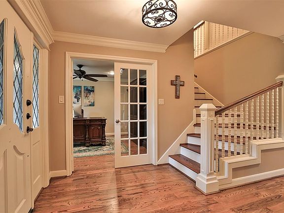 French double doors to the left lead to study. Notice the stairway up is also hardwood flooring. There is no carpeting in this home.