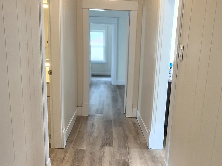 View down Hallway standing at Master Bedroom door. Left is Bathroom. Right is Family Room. Ahead is 2nd Bedroom, then doorway to 3rd Bedroom.