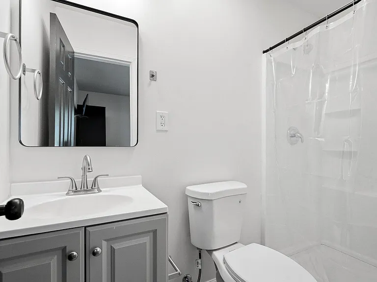 Clean full bathroom with a vanity sink, framed mirror, and a tub/shower combo with curtain for easy daily use.