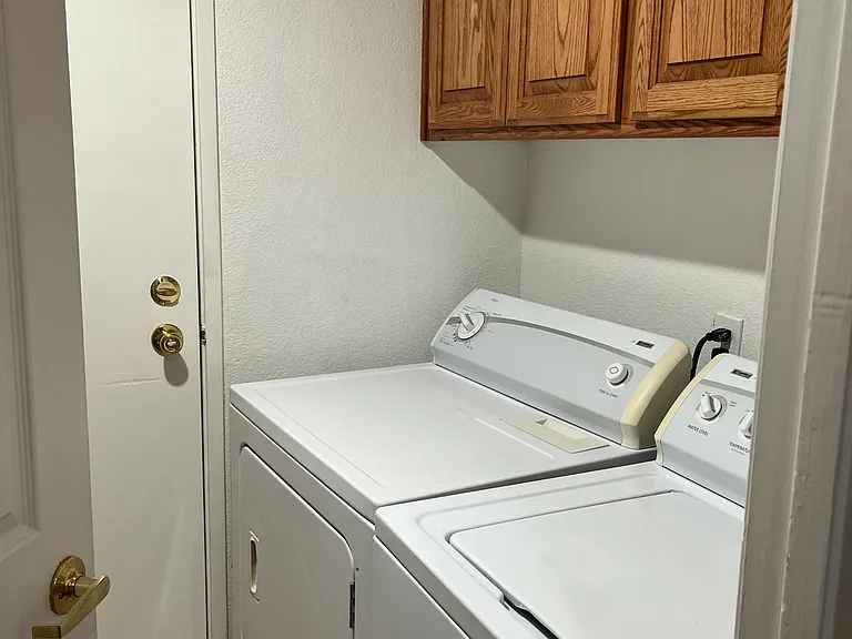 washer/dryer room with linen closet behind door.