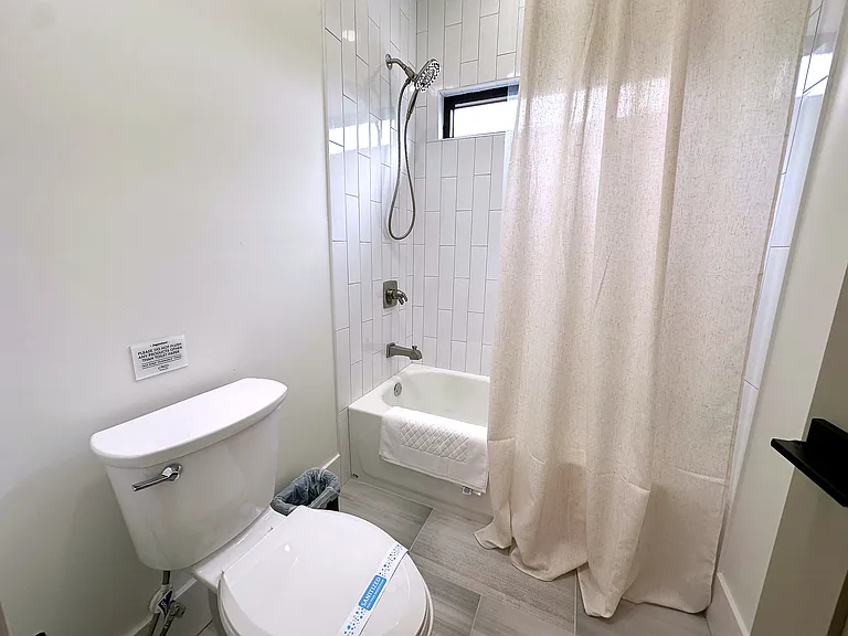 Double vanity bathroom, Apotheke luxury products, fully stocked amenities including blow dryer, luxe linen, and space to get ready. Spa bathroom with soaking tub, luxury bath products, shower, and soft curtain detail for a calm, retreat-like reset.