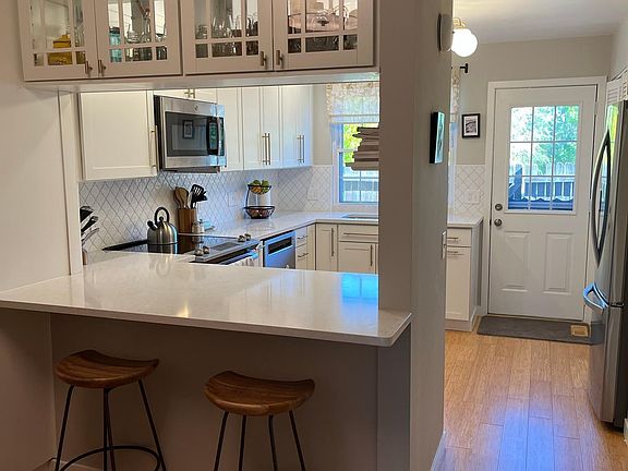 Quartz countertops, breakfast bar, and overhead cabinetry for additional storage.