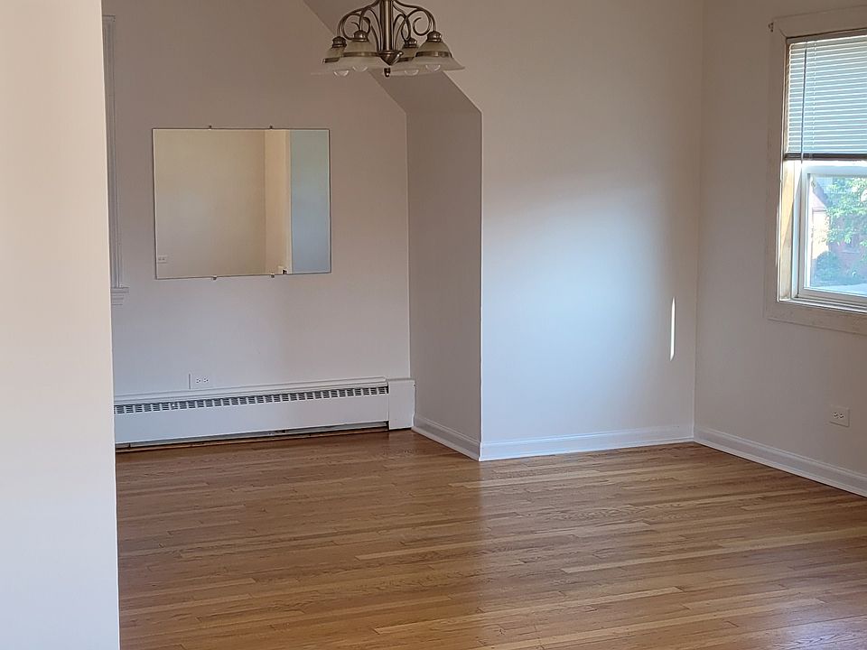 A bright, open sunny living room and dining room with hardwood floors.