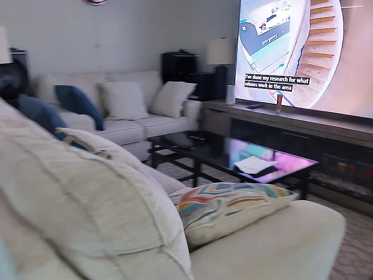 Living area with a sofa, armchair, and media console for relaxing and everyday entertaining.