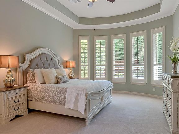 Serene and peaceful the Primary Bedroom has a tray ceiling, wall of windows, and recent carpet installed July 2020.