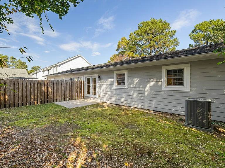 Backyard looking at home; fence gate to the side of home and opens towards front yard