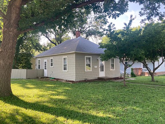 Side view of house with attached fence for trash can etc.
