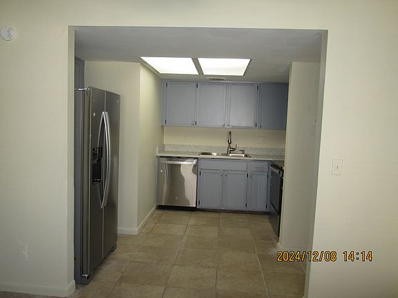 Kitchen - cabinets are gray with solid surface countertop. Stainless Steel Appliances