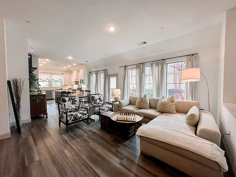 Living area with wall of windows and door out to pergola and yard