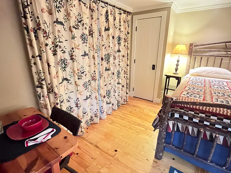 Full curtains on french doors and wooden blinds on windows for added privacy and light blocking.
