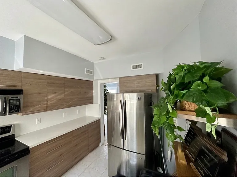 Kitchen (fridge angle)
Full-size stainless steel refrigerator, ample cabinetry, and a bright layout that makes cooking a pleasure