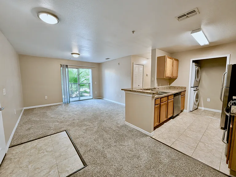 Bright and spacious apartment with an open-concept living area, modern kitchen, and large windows leading to a serene balcony view.