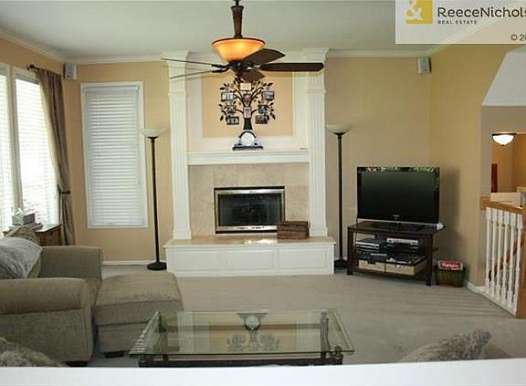 The great room offers a  wall of windows overlooking the backyard and a warm cozy fireplace.