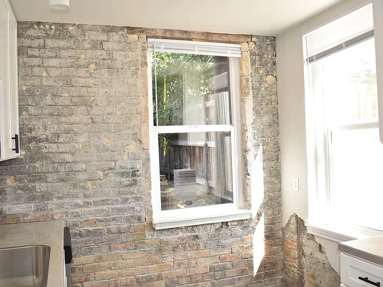 Exposed brick with a small brick reveal in the corner. Plenty of space for a breakfast table.
