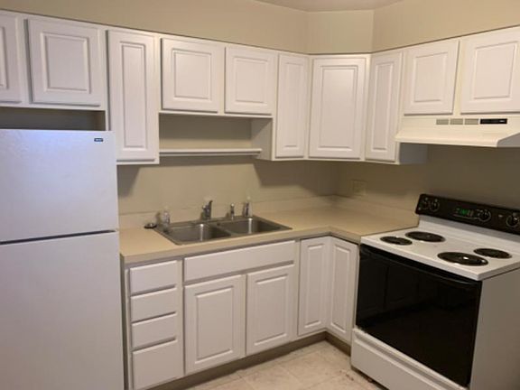 Kitchen with double sink, disposal, full-size range, & refrigerator